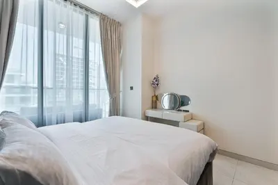 a white bedroom with a bed and a window at Venetian - Relax in your private pool balcony in Dubai in Dubai