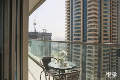 a table on a balcony with a view of a city at LIGHT APARTMENT by Design Studio in Dubai