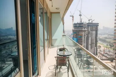 a balcony with a table and chairs on a building at LIGHT APARTMENT by Design Studio in Dubai