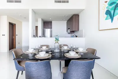 a dining room with a black table and chairs at GuestReady - Sea view retreat overlooking The Palm in Dubai