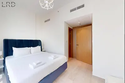a bedroom with a white bed and a wooden door at Chic 1BR with Canal View in Dubai
