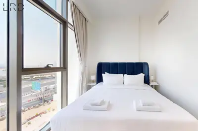 a bedroom with a bed and a large window at Chic 1BR with Canal View in Dubai