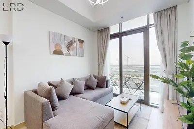 a living room with a couch and a large window at Chic 1BR with Canal View in Dubai