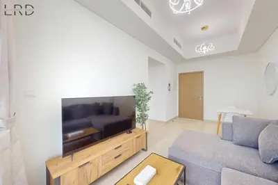 a living room with a couch and a flat screen tv at Chic 1BR with Canal View in Dubai