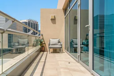 a balcony with two chairs on top of a building at Silkhaus Lavish 2BDR in Bay Square at Prime location in Dubai