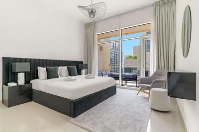 a bedroom with a large bed and a living room at Silkhaus Lavish 2BDR in Bay Square at Prime location in Dubai