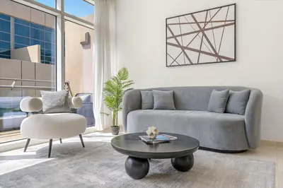 a living room with a couch and a table and a chair at Silkhaus Lavish 2BDR in Bay Square at Prime location in Dubai