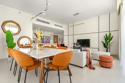 a living room with a table and chairs and a couch at Silkhaus Luxurious 3BR with Maid Room in Dubai Hills in Dubai