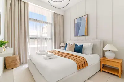 a white bedroom with a large bed and a window at Silkhaus Luxurious 3BR with Maid Room in Dubai Hills in Dubai