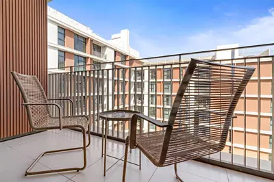a pair of chairs sitting on a balcony at Silkhaus Luxurious 3BR with Maid Room in Dubai Hills in Dubai