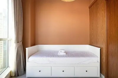 a small white bed with a stuffed animal on it at Panoramic Burj & Fountain Views 2BR in Dubai