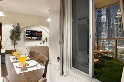 a dining room with a table and a view of a city at Panoramic Burj & Fountain Views 2BR in Dubai
