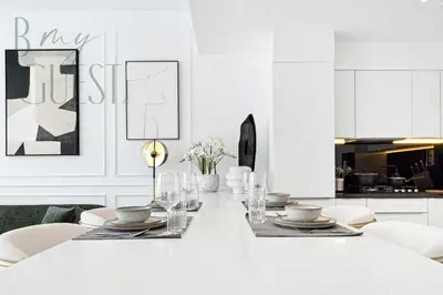a white kitchen with a white table and chairs at Remarkable one BR in Business Bay with Canal View in Dubai