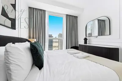 a bedroom with a white bed with a large window at Remarkable one BR in Business Bay with Canal View in Dubai