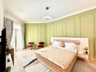 a bedroom with green walls and a large bed at Palm Paradise Walk to Beach in Dubai
