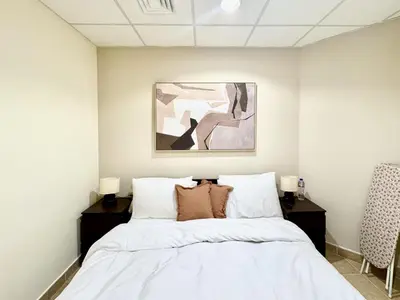 a bedroom with a bed with white sheets and pillows at Palm Paradise Walk to Beach in Dubai