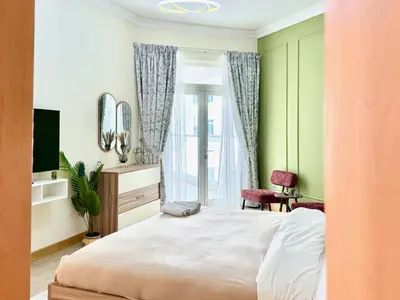 a bedroom with a large bed and a window at Palm Paradise Walk to Beach in Dubai