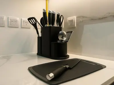 a black holder with utensils on a table at Cozy New Studio Heart of Al Furjan in Dubai