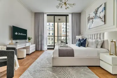 a white bedroom with a bed and a living room at Luxury at Its Finest, 2BR with Private Indoor Pool in Dubai