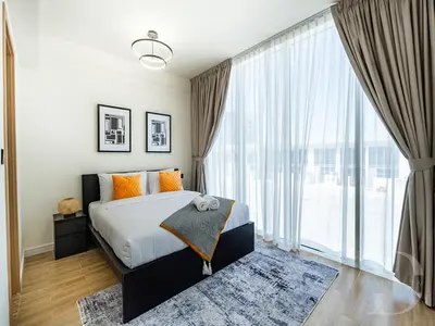 a bedroom with a bed and a large window at Cozy house suitable for family in Dubai