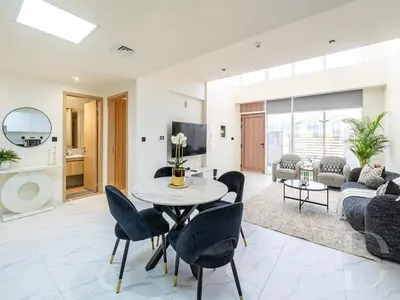 a living room with a table and chairs at Cozy house suitable for family in Dubai