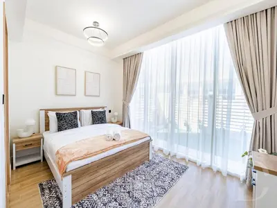 a bedroom with a bed and a large window at Cozy house suitable for family in Dubai