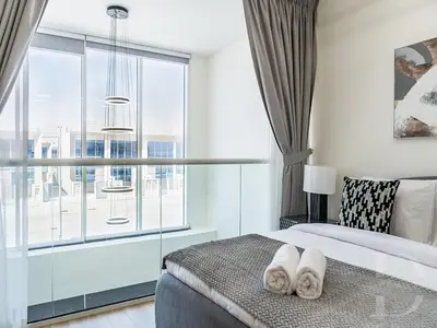 a bedroom with a bed and a large window at Cozy house suitable for family in Dubai