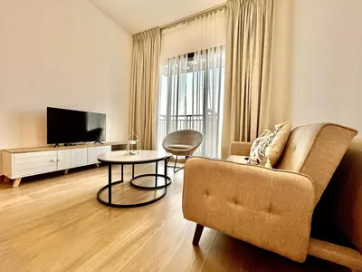 a living room with a couch and a table at Homes2Retreat - Modern Comforts 1 BR in Liva Lush Living in Dubai