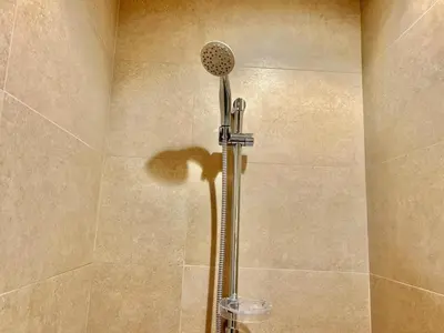 a shower stall with a shower head in a bathroom at Homes2Retreat - Modern Comforts 1 BR in Liva Lush Living in Dubai