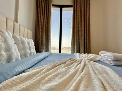 a bedroom with a bed with a large window at Homes2Retreat - Modern Comforts 1 BR in Liva Lush Living in Dubai