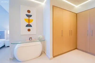 a bathroom with a toilet with a glass counter at Gardenia Suites Creek Harbour, 2 Bedroom Stylish Apartment with Creek Views in Dubai
