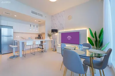 a kitchen and dining room with a table and chairs at Gardenia Suites Creek Harbour, 2 Bedroom Stylish Apartment with Creek Views in Dubai