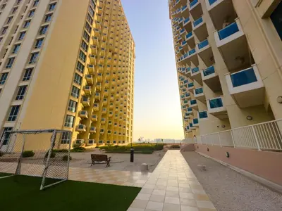 a view of two tall buildings with a net at Spacious 2BR in Lago Vista Tower in Dubai