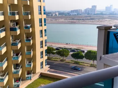a view from the balcony of a building with a view of the ocean at Spacious 2BR in Lago Vista Tower in Dubai