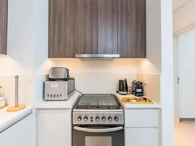 a kitchen with a stove and a microwave at Stylish Dubai Hills Retreat 1BR-Park Heights 2 T2 in Dubai