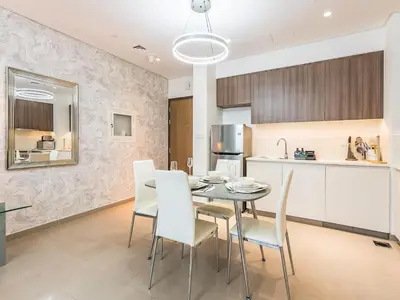 a kitchen and dining room with a table and chairs at Stylish Dubai Hills Retreat 1BR-Park Heights 2 T2 in Dubai