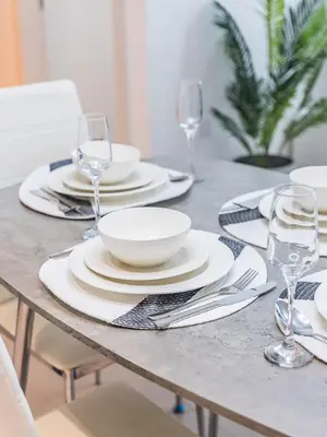 a table with plates and bowls and wine glasses at Stylish Dubai Hills Retreat 1BR-Park Heights 2 T2 in Dubai