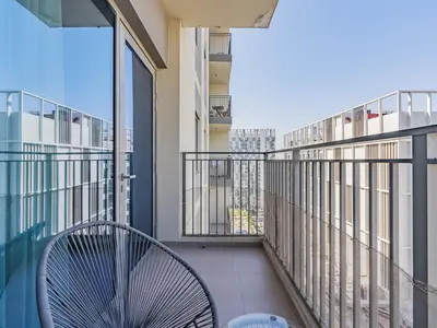 a balcony with a chair and a view of the city at Stylish Dubai Hills Retreat 1BR-Park Heights 2 T2 in Dubai