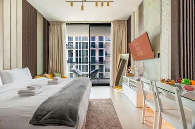 a hotel room with two beds and a desk at DAYF-LAV Brand New Apartment with Balcony in JVC in Dubai