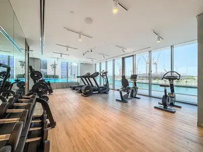 a gym with treadmills and exercise equipment in a building at Stylish 1 BR in Canal Front with Pool and Gym Access in Dubai
