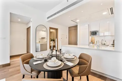a dining room with a table and chairs and a kitchen at Stylish 1 BR in Canal Front with Pool and Gym Access in Dubai