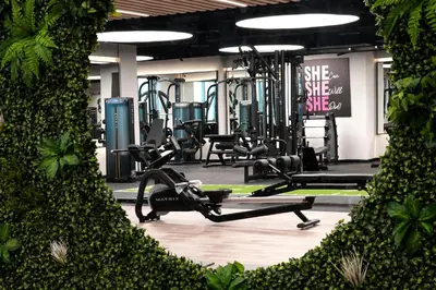 a gym with treadmills and exercise equipment and plants at Luxury Studio Near Burj Khalifa in Dubai