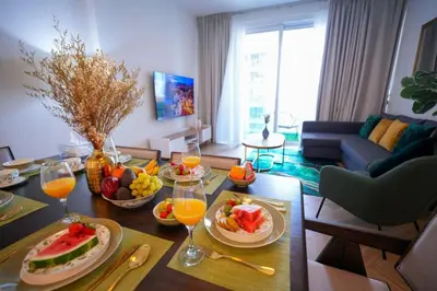 a living room with a table with fruits and wine glasses at Modern 1BR 4 guest apartment World Trade Center in Dubai