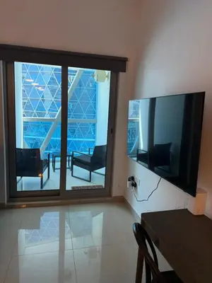 a living room with a large window and a television at Modern Studio in Damac Park Tower - Near Dubai Mall & Metro in Dubai