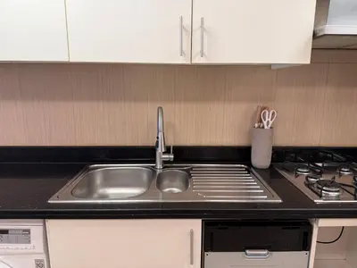a kitchen counter with a sink and a stove at Modern Studio in Damac Park Tower - Near Dubai Mall & Metro in Dubai