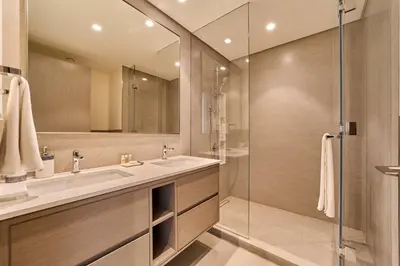 a bathroom with a sink and a glass shower at FAM Living Grande 2Bed with Panoramic Burj Khalifa Fountain View in Dubai