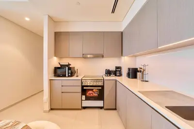 a kitchen with a stove and a microwave at FAM Living Grande 2Bed with Panoramic Burj Khalifa Fountain View in Dubai