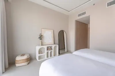 a white bedroom with a bed and a mirror at Luxury 3BR & Maid - Canal View - Near Downtown in Dubai