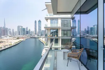 a balcony with chairs and a view of a river at Luxury 3BR & Maid - Canal View - Near Downtown in Dubai