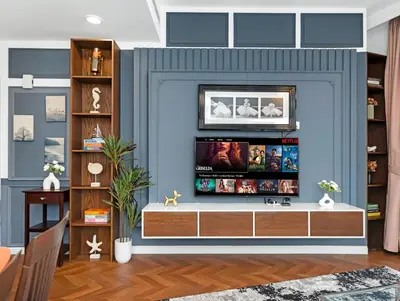 a living room with a tv against a blue wall at Burj Khalifa View 2 Bedroom Apartment in Dubai